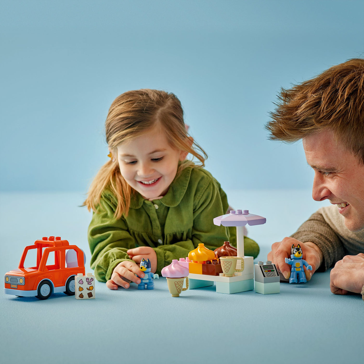 Visita alla gelateria di Bluey fotografia bambina e uomo che giocano con il set lego duplo costruito
