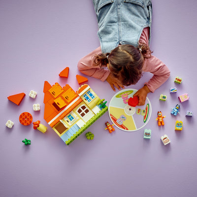 Casa della Famiglia di Bluey con gioco di memoria fotografia dall'alto del set duplo in costruzione con bambina