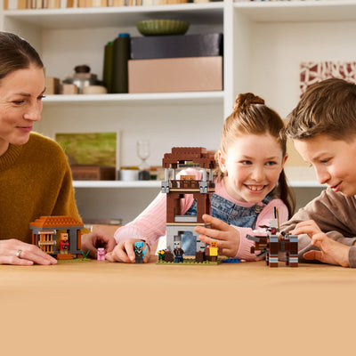 L’avamposto del saccheggiatore e predone fotografia bambini e donna che giocano con il set lego