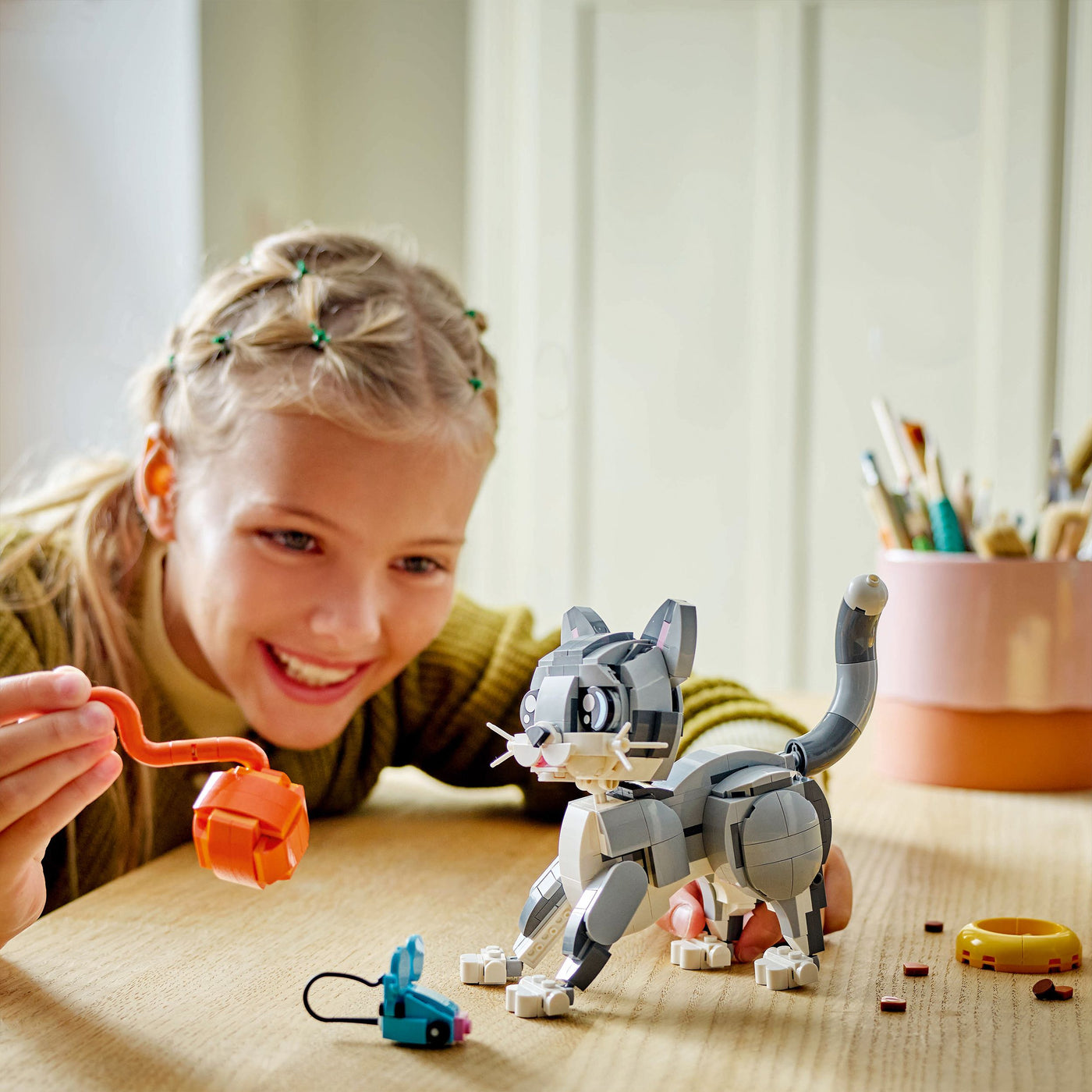 Gatto giocoso fotografia bambina che gioca con il set lego
