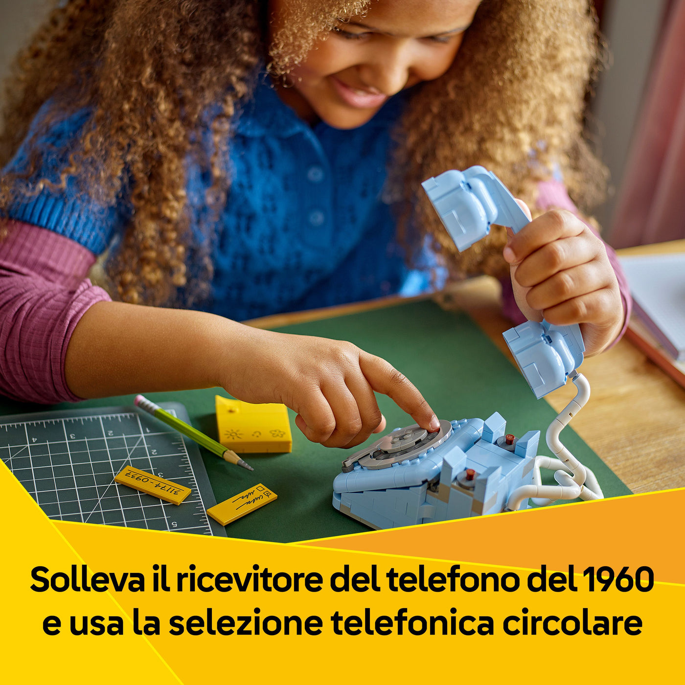 Telefono retrò fotografia bambina che gioca con il set lego "Solleva il ricevitore del telefono del 1960 e usa la selezione telefonica circolare"