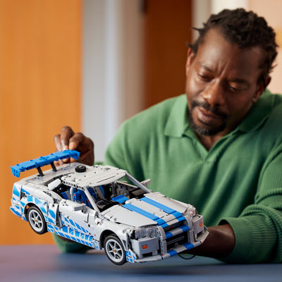 Auto Nissan Skyline GT-R (R34) 2 Fast 2 Furious fotografia uomo con set lego tra le mani