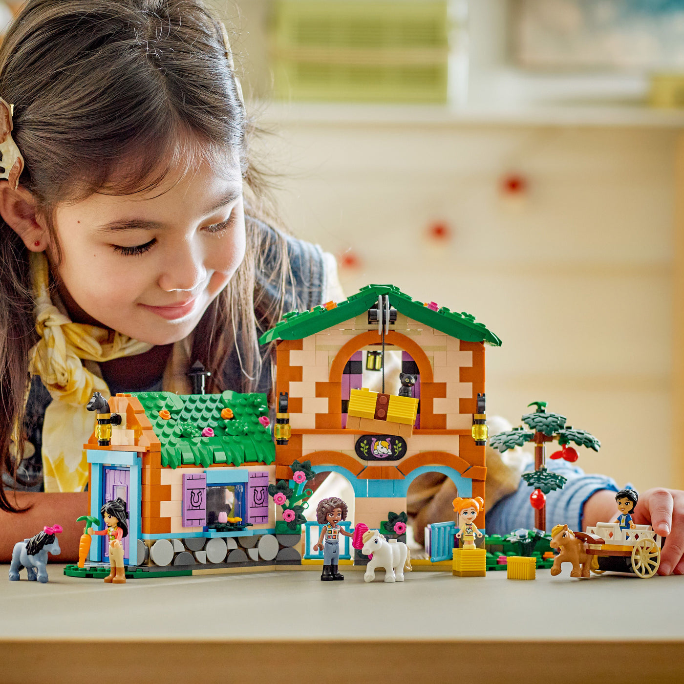 Ranch e scuderia dei pony fotografia frontale del set lego costruito e bambina che ci gioca