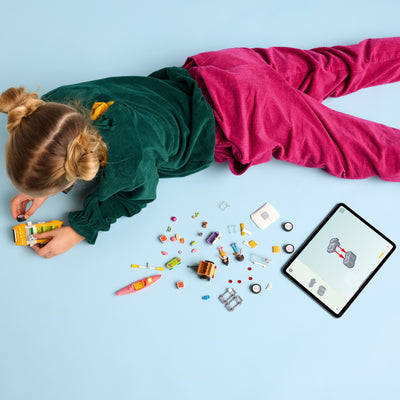 Viaggio in auto con il cucciolo fotografia dall'alto del set lego in costruzione con bambina
