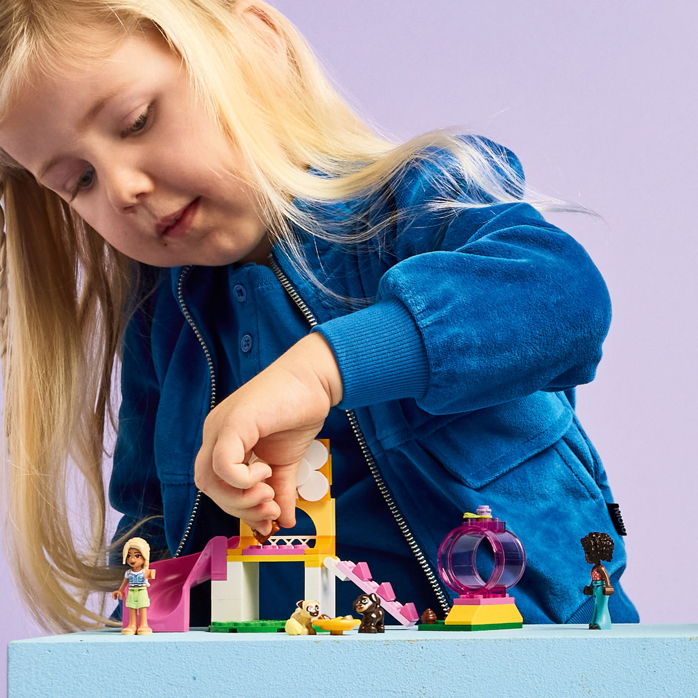 Il parco giochi dei cuccioli fotografia bambina che gioca con il set lego costruito