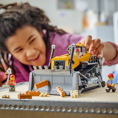 Bulldozer giallo fotografia bambino che gioca con il set lego costruito