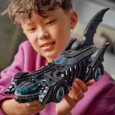 Batmobile™ Batman Forever™ fotografia bambino che tiene tra le mani il set lego costruito