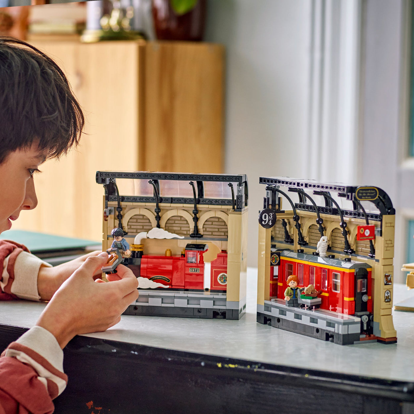 Book Nook: Espresso per Hogwarts™ fotografia ragazzino che tiene tra le mani il set lego