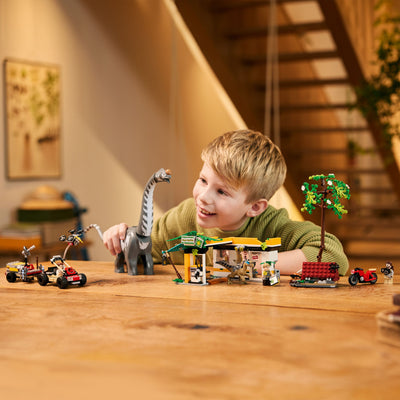 Alla ricerca del Raptor e del Titanosauro fotografia bambino che gioca con il set lego costruito su un tavolo di casa