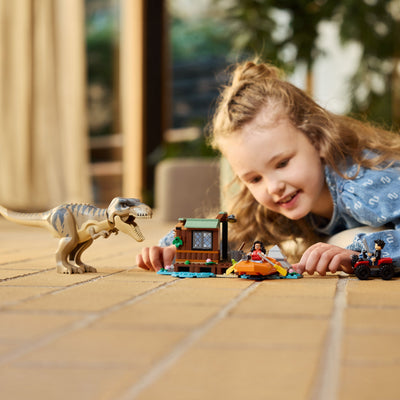 Fuga sul fiume dal T. rex fotografia bambina che gioca con il set lego