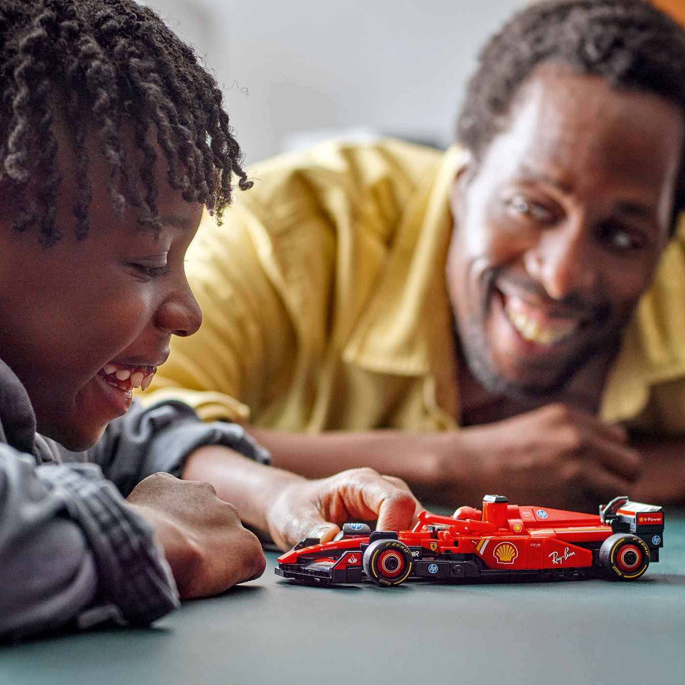 Auto da corsa F1® Ferrari SF-24 fotografia bambino e uomo che giocano con il set lego costruito