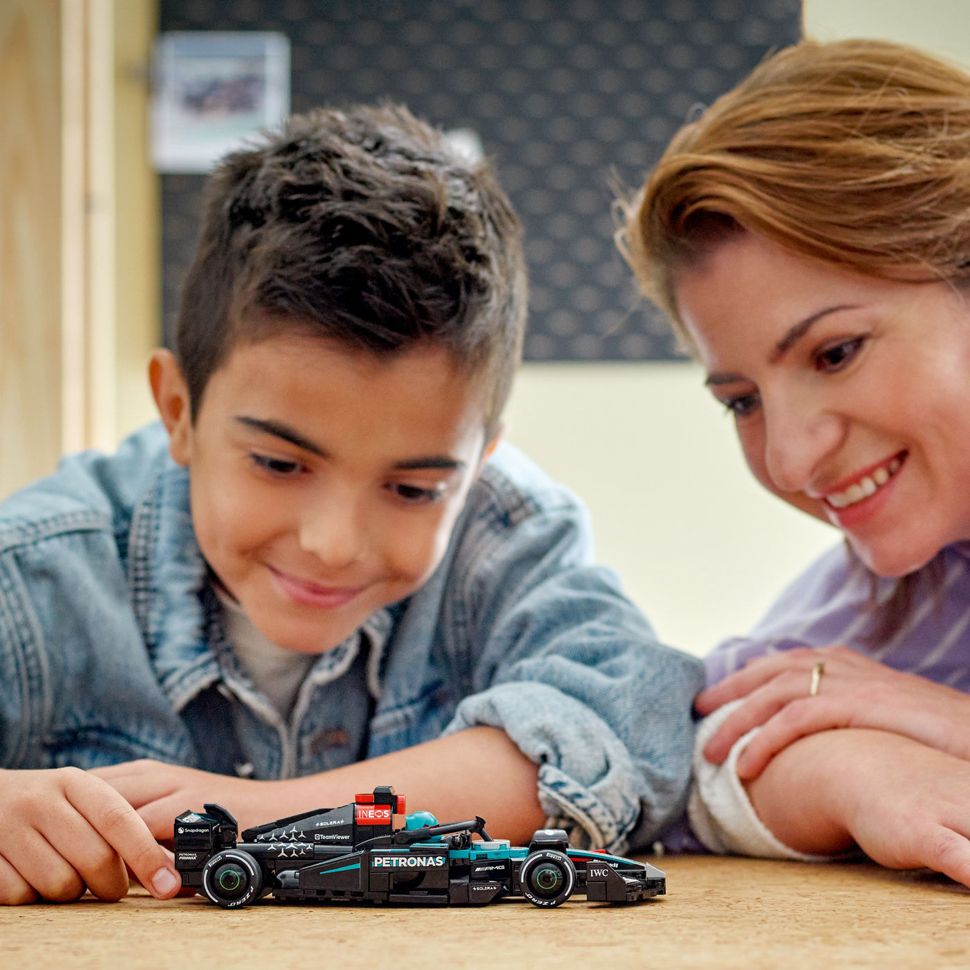 Auto da corsa Mercedes-AMG F1® W15 fotografia bambino e donna che osservano il set lego costruito