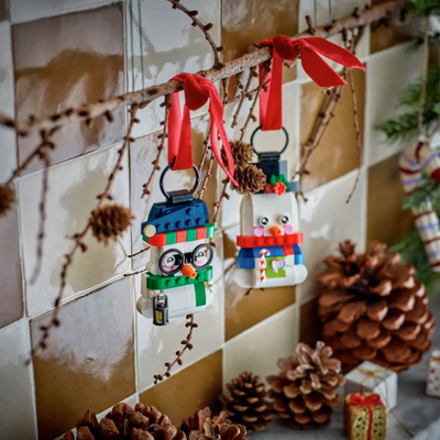 Pupazzi di neve ornamentali fotografia del set lego appeso ad un ramo decorativo in ambiente domestico da esposizione